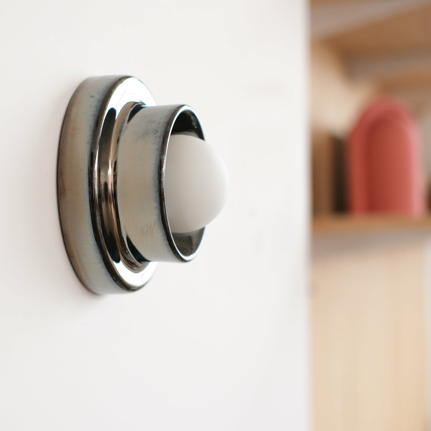 Misewell Q Sconce Handcrafted Ceramic Wall Light in Chrome on a white wall