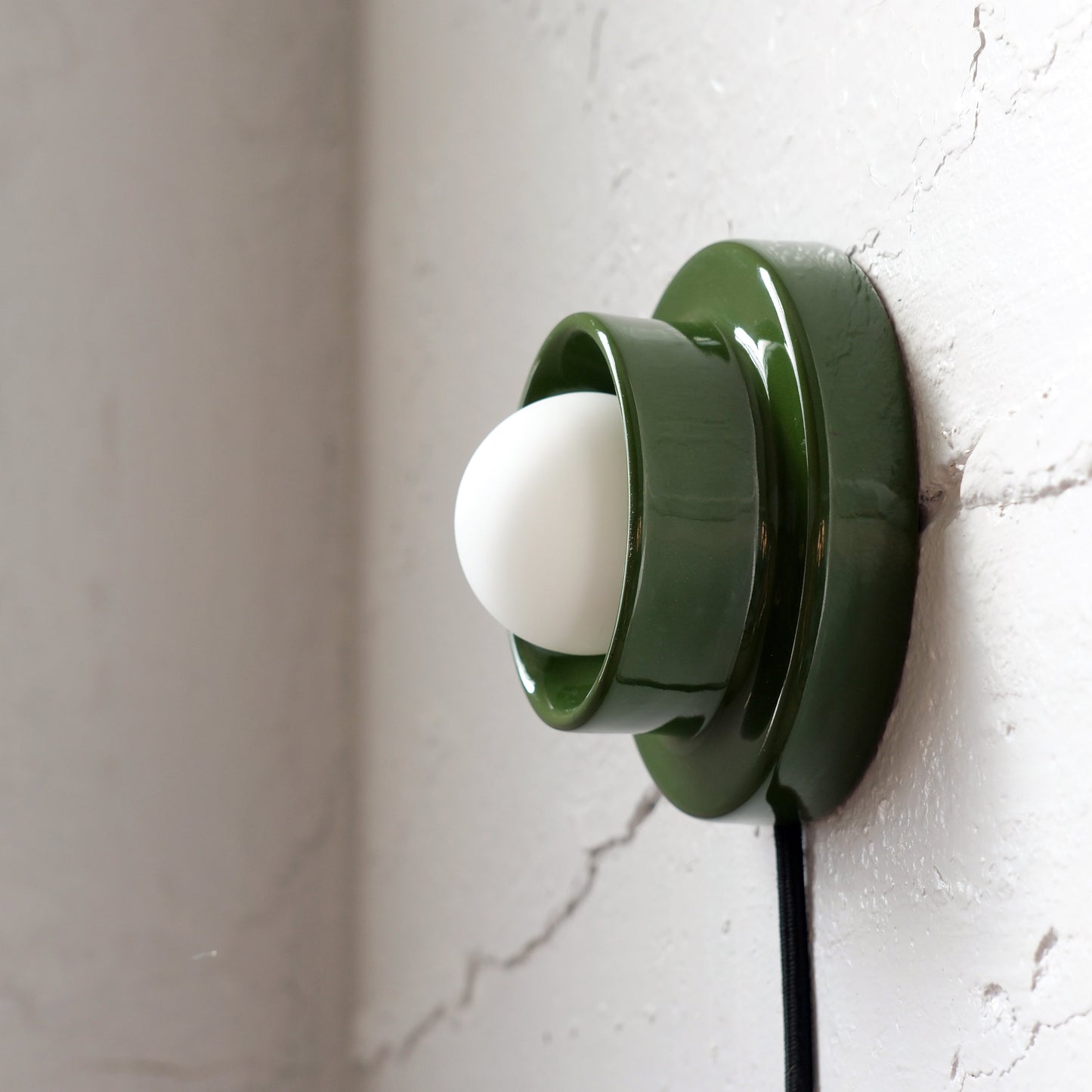 Green Misewell Q Sconce Handcrafted Ceramic Wall Light on a white wall