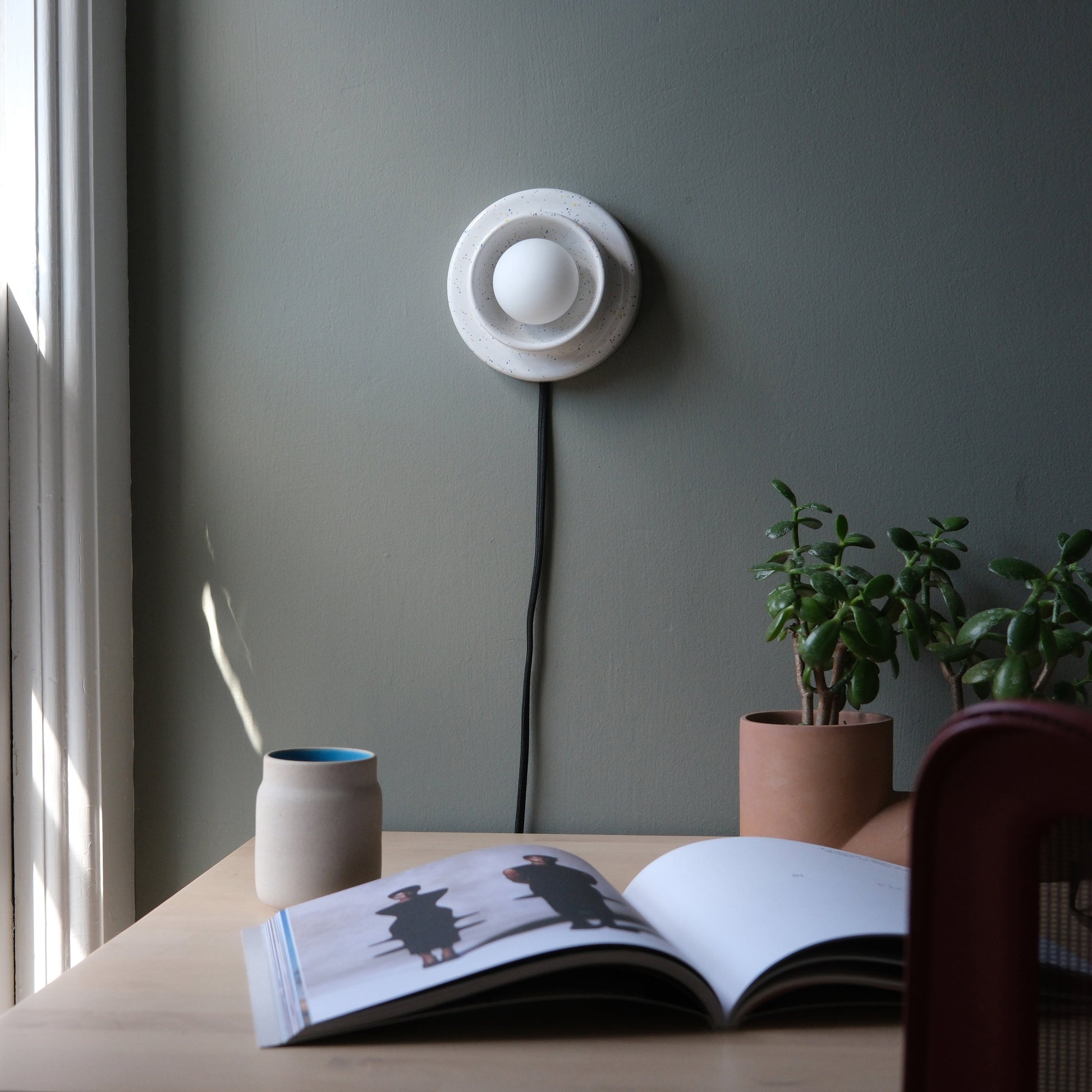 Speckled Misewell Q Sconce Handcrafted Ceramic Wall Light on a white wall