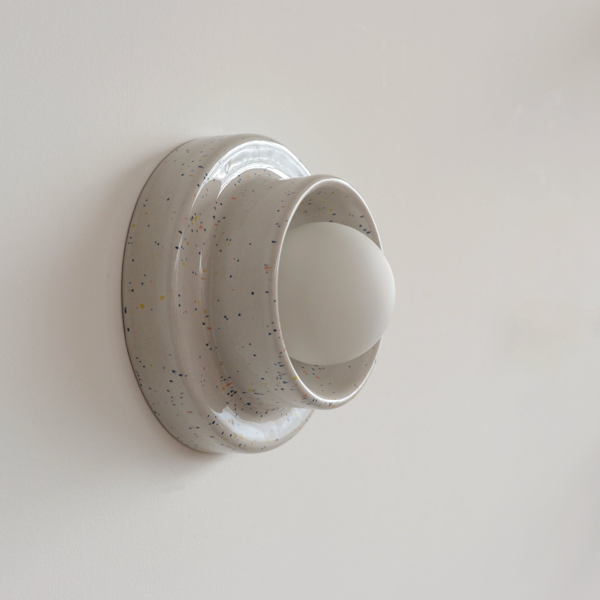 Misewell Q Sconce Handcrafted Ceramic Wall Light in Speckle on a white wall
