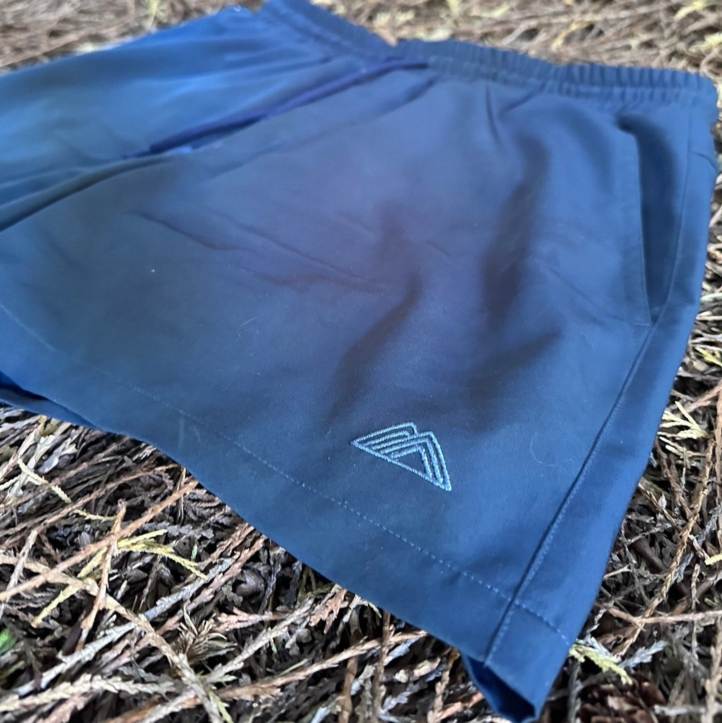 Athletic 5 Inch Recycled Shorts in Deep navy by Rainier Watch with a logo on a natural background