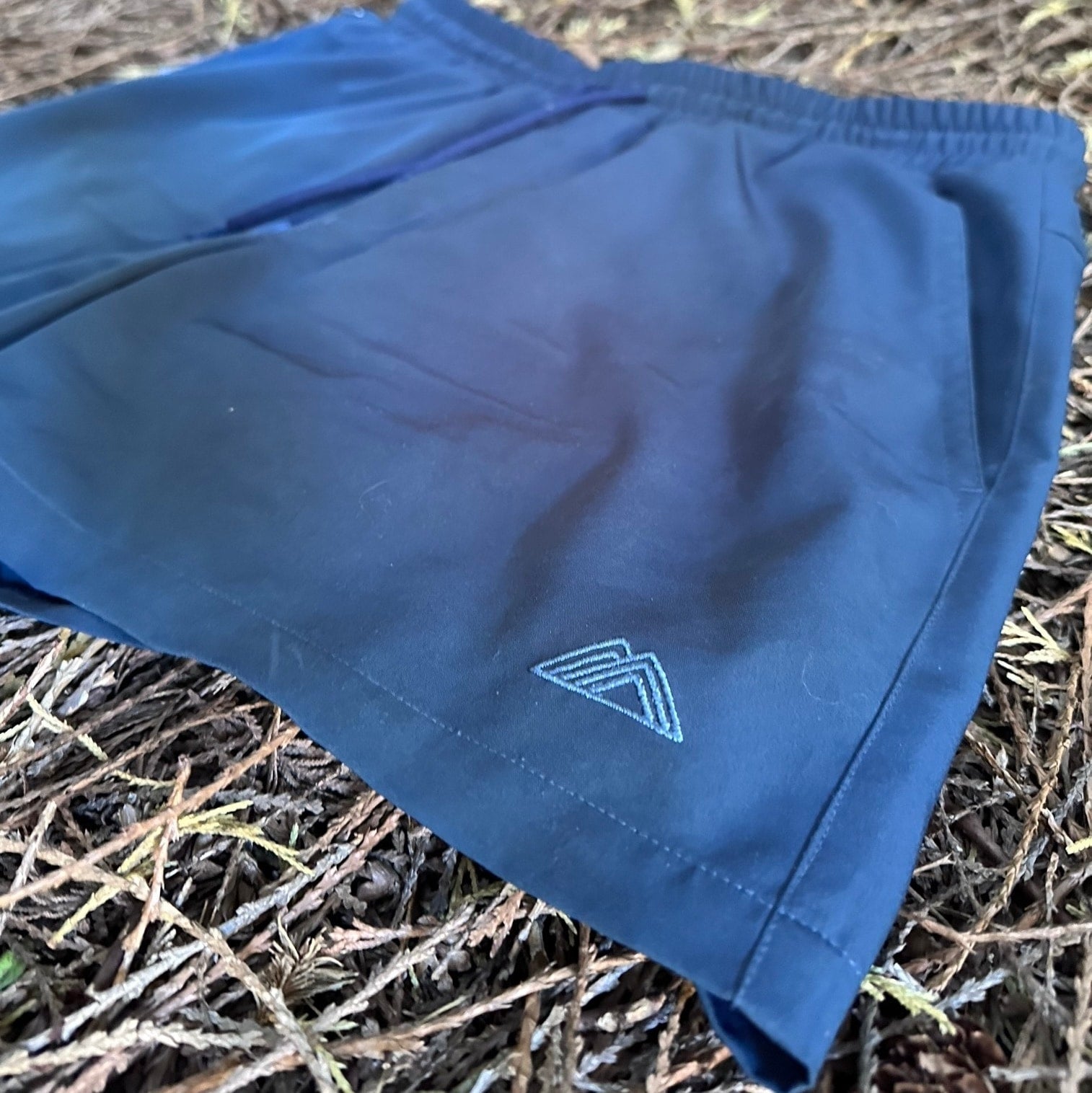 Athletic 5 Inch Recycled Shorts in Deep navy by Rainier Watch with a logo on a natural background