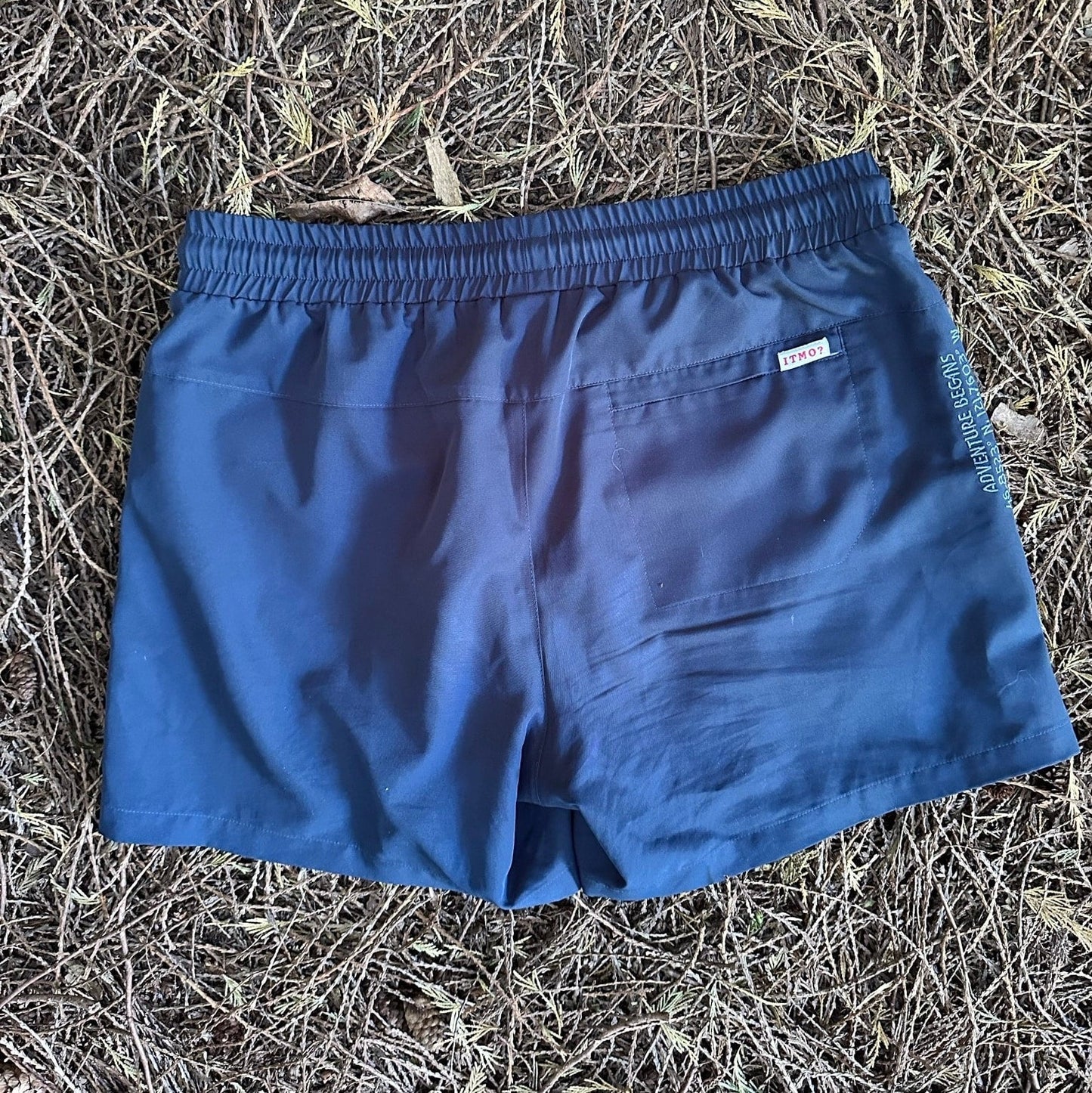 Athletic 5 Inch Recycled Shorts in Deep Navy by Rainier Watch on a textured brown surface
