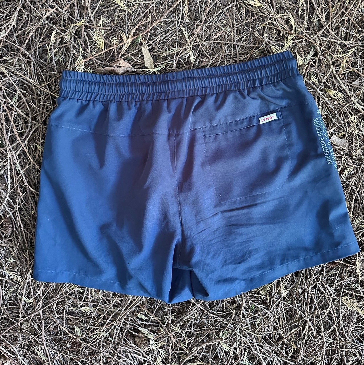 Athletic 5 Inch Recycled Shorts in Deep Navy by Rainier Watch on a textured brown surface