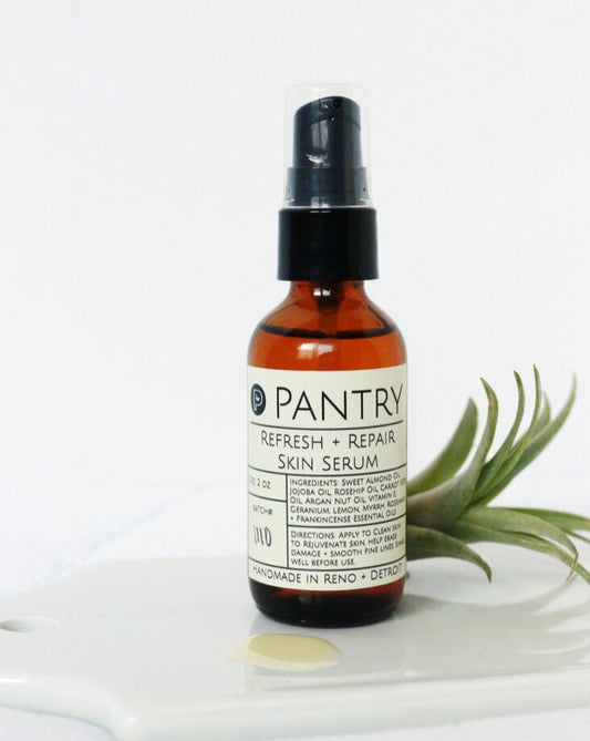 Pantry Refresh & Repair Skin Serum spray bottle on a white background with a plant.