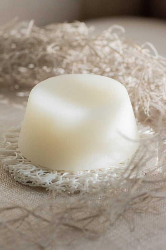 White shampoo bar on a textured beige surface