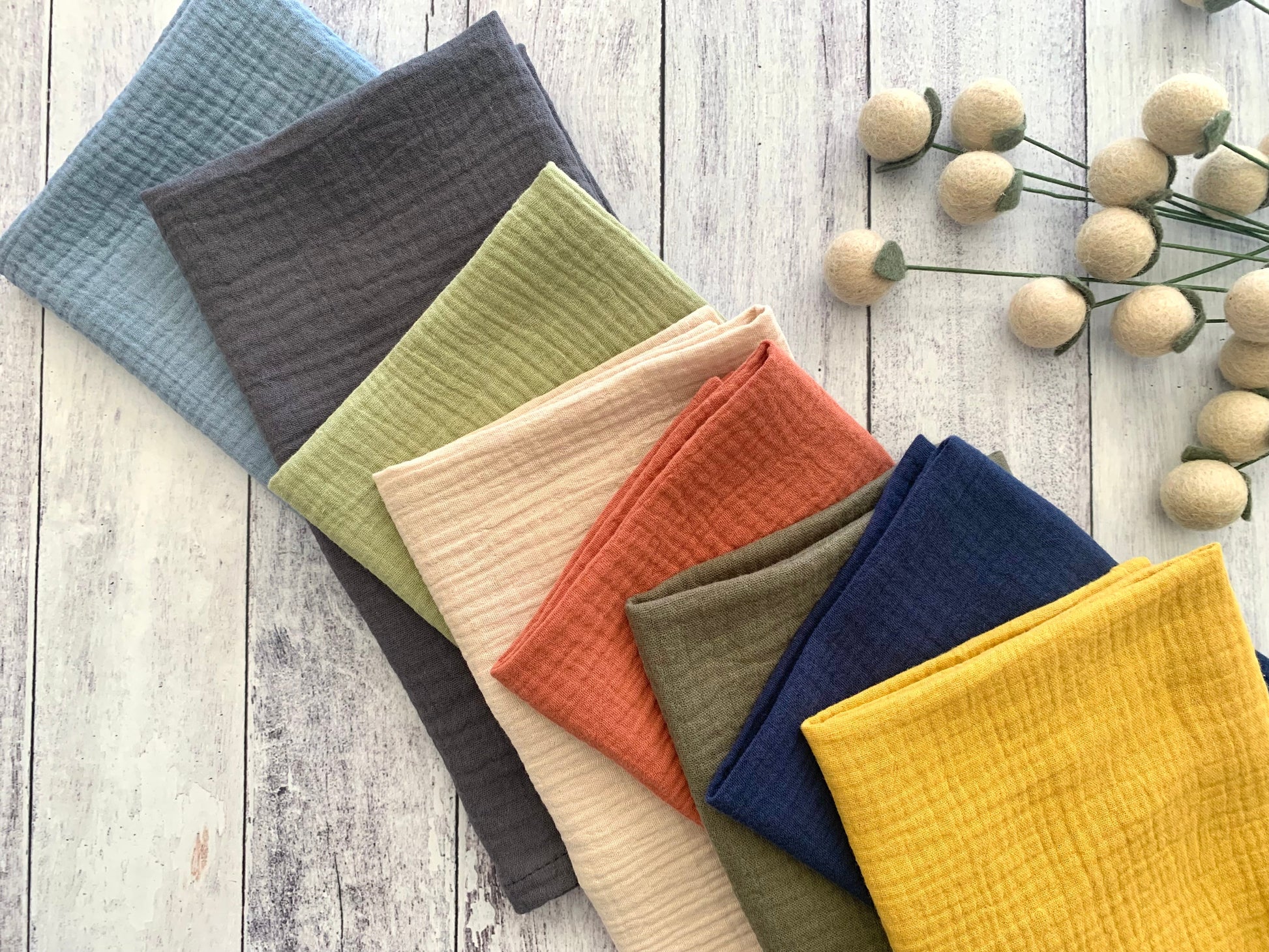 Colorful 100% crinkle cotton dinner napkins (set of 4) from Dot and Army, arranged on a wooden surface