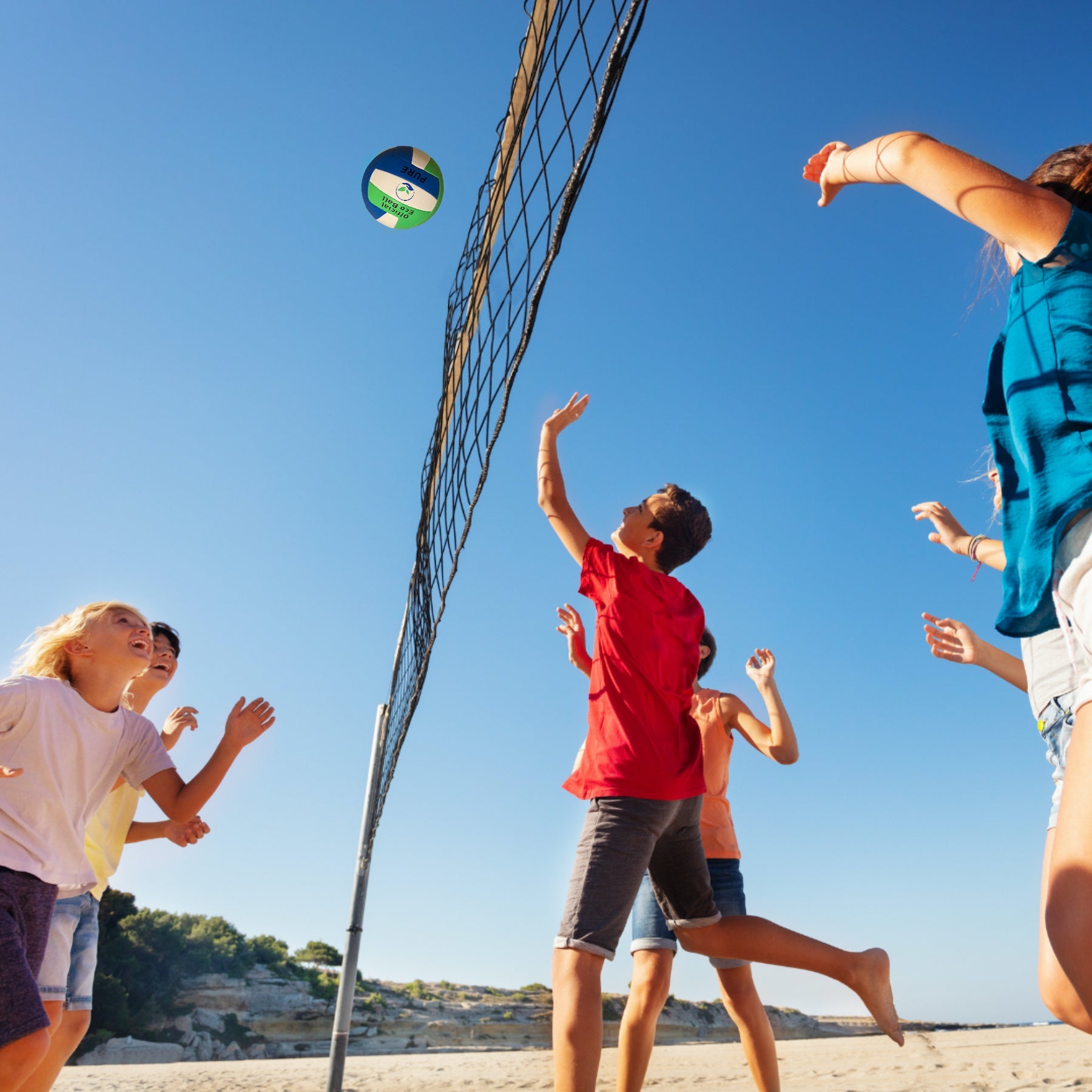 Eco Sports eco-friendly vegan Beach Volleyball in play with a group of kids at a beach.