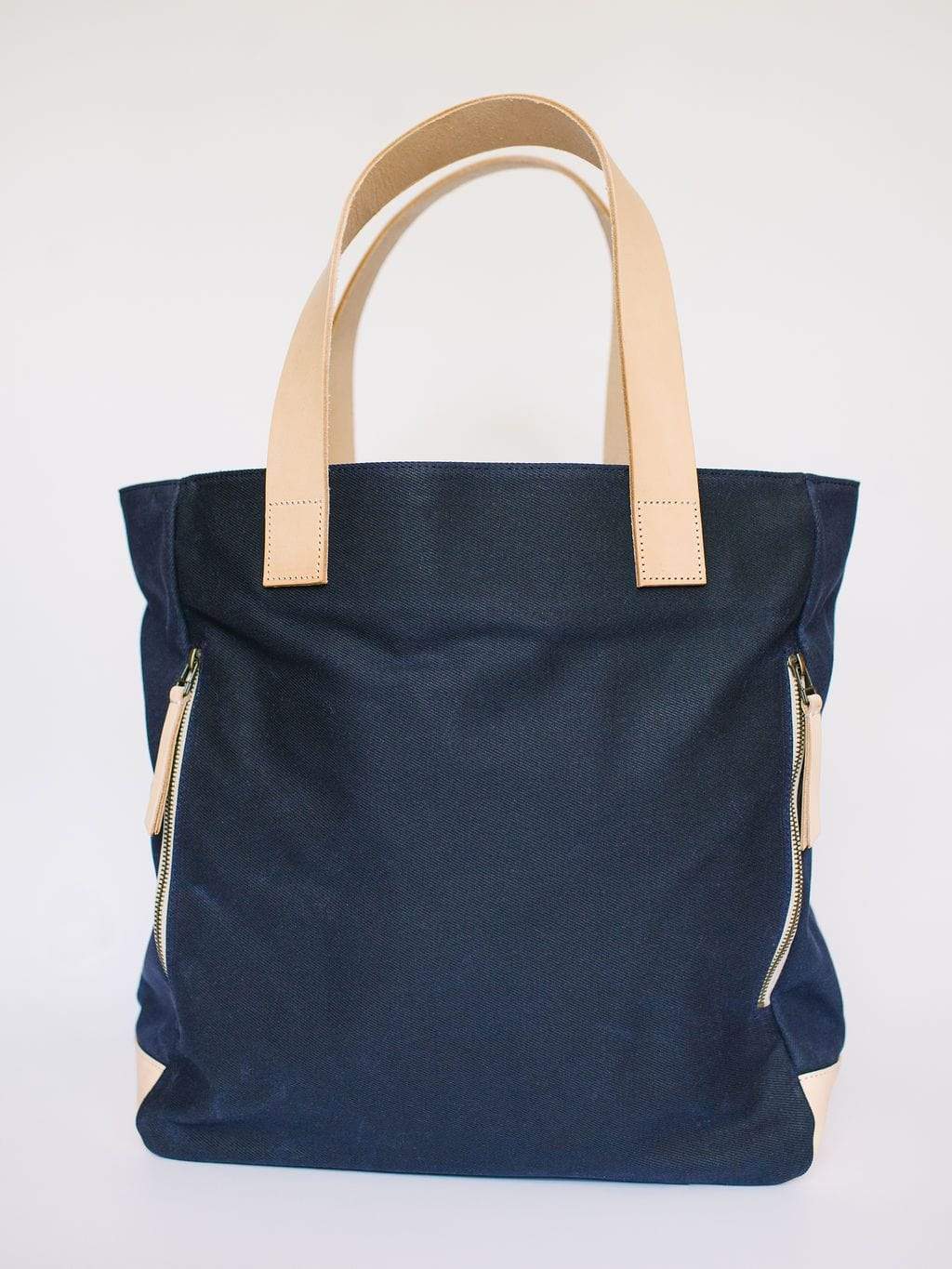 Waxed Canvas Tote Bag – Navy with Bright Pink Lining, Durable & Eco-Friendly, with beige handles and zippers on a white background