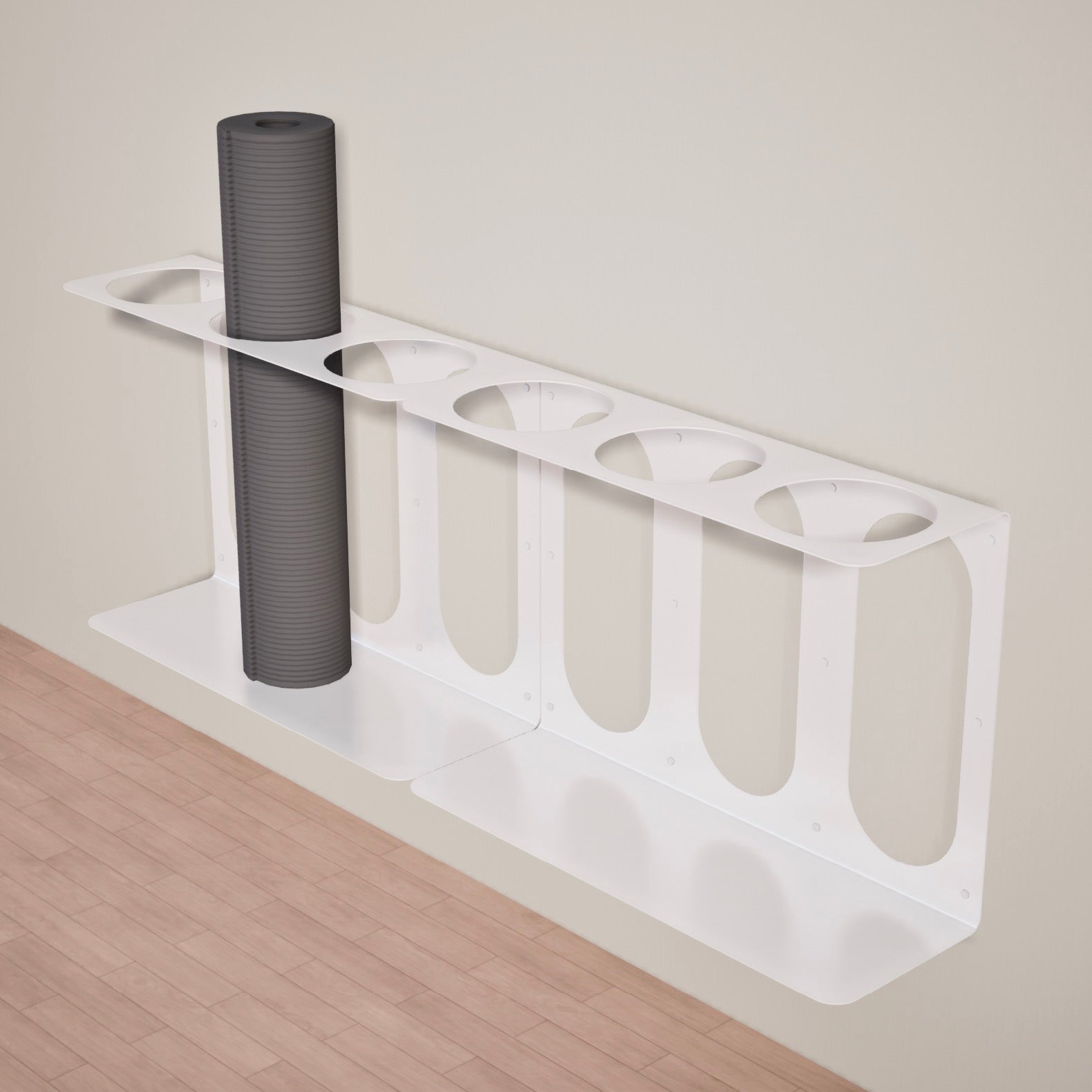 Two white Yoke yoga mat wall brackets mounted side-by-side with a gray yoga mat on one of the 3 available slots, on a wooden floor against a beige wall